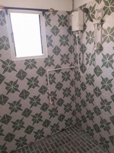 a bathroom with gray and green tiles on the wall at Coastal Paradise in Sigatoka +18 photos