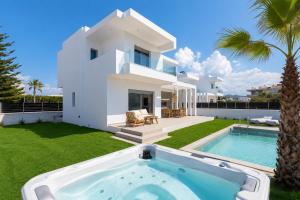 a villa with a swimming pool and a house at Martini Villas in Kremasti