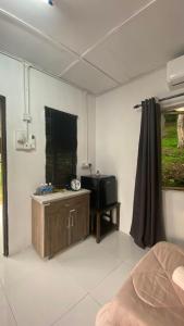 a room with a bed and a tv in it at Durian Chalet in Kuala Tahan