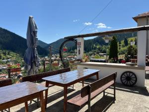 a table and benches on a balcony with a view at Къща за гости Изгрев in Trigrad
