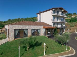 a house with a green yard in front of a building at Agroturizem Prelude in (( Barç ))