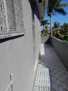 a white building with a gate and a palm tree at Coastal Paradise in Sigatoka