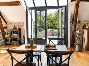 a living room with a table and chairs and a window at La Cidraisy in Grisy-les-Plâtres