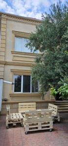 a building with benches and a tree in front of it at Casa Villa in Baku