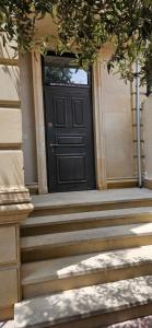 a black door on a house with stairs at Casa Villa in Baku