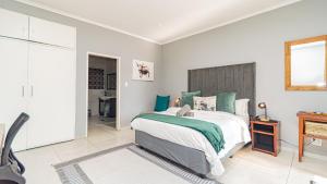 a bedroom with a bed and a wooden headboard at Bosveld In Die Stad 2 Guesthouse in Alberton +63 photos