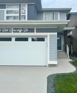 a white garage door in front of a house at AYBAM's House in Winnipeg