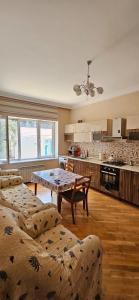 a living room with a table and a kitchen at Casa Villa in Baku
