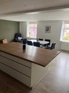a room with a large counter with chairs and a table at Niollo Hotels in Aabenraa