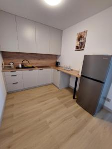 a kitchen with a refrigerator and a table in it at Nowy Zakątek in Paszkówka