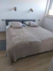 a bedroom with a large bed with two pillows at Nowy Zakątek in Paszkówka