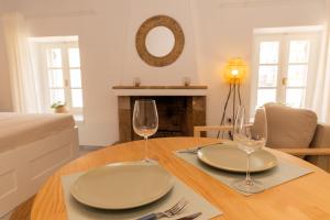 a dining room table with two plates and wine glasses at Emerald Courtyard House in Kranidi