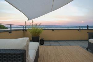 a balcony with a couch and a view of the ocean at L'Effet Papillon - Maison d'hôtes in Sauges