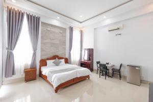 a bedroom with a bed and a table and chairs at Hotel TRUNG LÀI in Tây Ninh