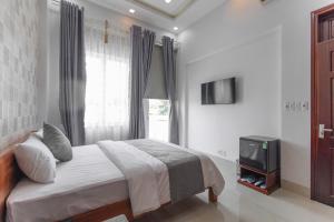 a bedroom with a bed and a tv and a window at Hotel TRUNG LÀI in Tây Ninh