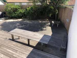 a wooden bench sitting on a wooden deck at Villa Maude & Jean in Lacanau-Océan
