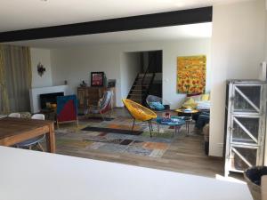 a living room with colorful chairs and a table at Villa Maude & Jean in Lacanau-Océan