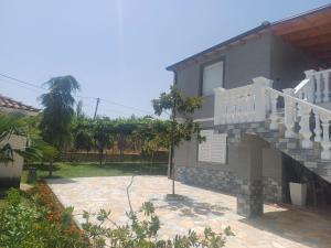 a house with a staircase next to a yard at Hamit House Vacation in Fier