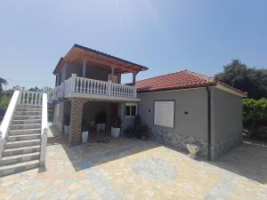 a house with a balcony and a staircase at Hamit House Vacation in Fier