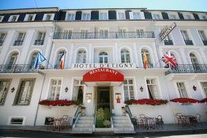 un exterior de hotel con mesas y sillas delante en Hôtel d'Etigny en Luchon