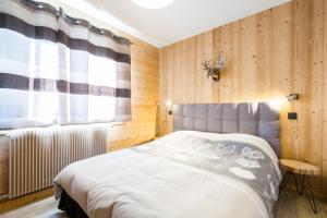 a bedroom with a bed and a window at Cozy chaleett on SLOPES in Crest-Voland