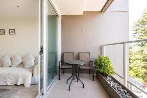 a balcony with a table and chairs and a bed at SUNSET GETAWAY GLENELG in Glenelg +17 photos