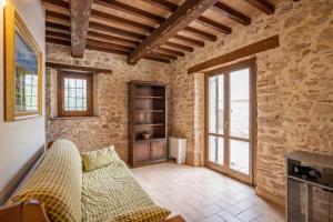 a living room with a couch in a stone wall at House Morro di Rasiglia in Rasiglia