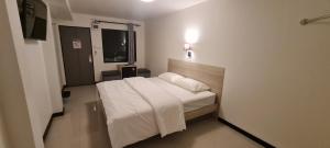 a bedroom with a white bed in a room at ห้องพักรายวัน168 in Ban Amphaeng