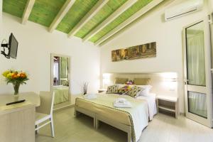 Schlafzimmer mit einem Bett, einem Schreibtisch und einem Tisch in der Unterkunft Agriturismo Il Megalite in Giurdignano