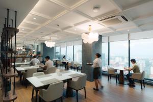 a restaurant with people sitting at tables in a cafeteria at Champs Elysees Hotel & Suites in Phnom Penh