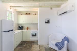 a kitchen with white cabinets and a white chair in it at Serifos View in Serifos Chora