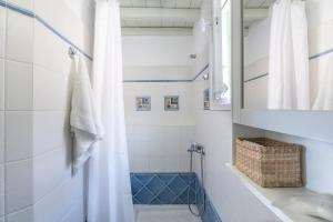 a bathroom with a shower with a sink and a mirror at Serifos View in Serifos Chora +27 photos