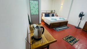 a bedroom with a bed and a tea kettle on a table at Ella Hermitage View in Ella