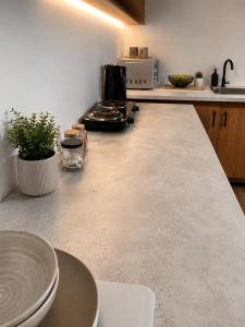 a kitchen with a counter top with plates on it at Suider Ozias Self Catering in Windhoek