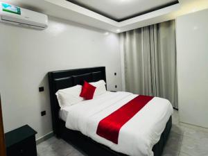 a bedroom with a bed with a red and white blanket at Appartements Rebero Hills in Kigali