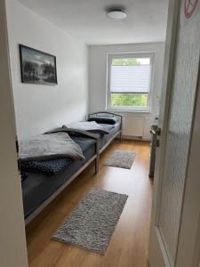 two beds in a room with a window and two rugs at Silkes FeWo in Sollstedt