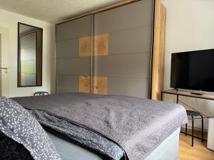 a bedroom with a large bed and a flat screen tv at Silkes FeWo in Sollstedt