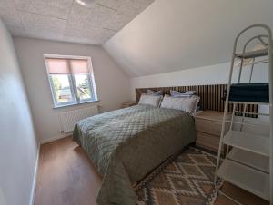 a bedroom with a bed and a window and a ladder at Kølkær B&B in Kølkær