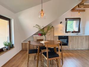 a kitchen with a wooden table and chairs at Dana apartment with Garden near Tara National Park in Bajina Bašta