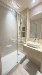 a bathroom with a glass shower and a sink at Azur Stay Nice in Nice