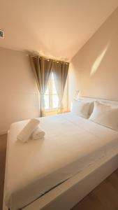 a white bed with white pillows and a window at Azur Stay Nice in Nice