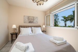 a bedroom with a large bed with a large window at Gaia Residence in Argostoli +70 photos