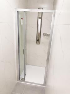 a shower with a glass door in a bathroom at The Central Dublin Hostel in Dublin