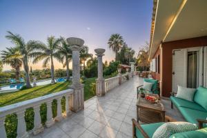 a balcony with a view of a pool and palm trees at Gaia Residence in Argostoli