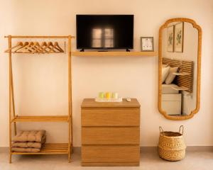 a room with a shelf and a mirror and a dresser at Emerald Courtyard House in Kranidi