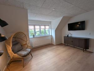 a living room with a chair and a flat screen tv at Kølkær B&B in Kølkær