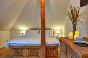 a bedroom with a canopy bed and a wooden dresser at Boutique hotel Pod Barborou in Kutná Hora