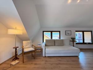 a living room with a white couch and a chair at Dana apartment with Garden near Tara National Park in Bajina Bašta +29 photos