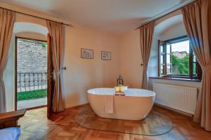 a bath tub in a room with a large window at Boutique hotel Pod Barborou in Kutná Hora +30 photos