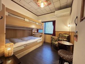 a room with a bunk bed and a table and chairs at Guest House Oumi in Kyoto